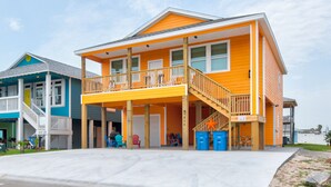 A two-story house with a balcony, wooden deck, and a garage.