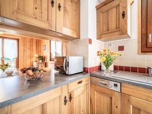 Enjoy cooking in this well-equipped kitchen with a dishwasher, window view, and beautiful outdoor scenery.