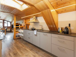 Una cucina moderna con un lucernario, travi in legno e una macchina da caffè.