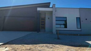 Een modern gebouw met een garage, een groot raam en een heldere lucht.