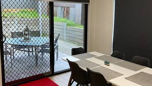 Een vergaderzaal met een grote tafel, stoelen en een projectiescherm.