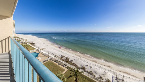 Ein Balkon mit Blick auf Strand und Meer.