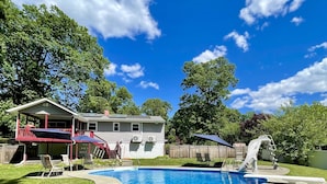 A house with a swimming pool, a covered patio, and a fenced yard.