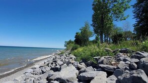 Eine felsige Küstenlinie mit blauem Himmel und ruhiger See.