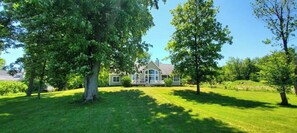 A house surrounded by lush green trees and grass.