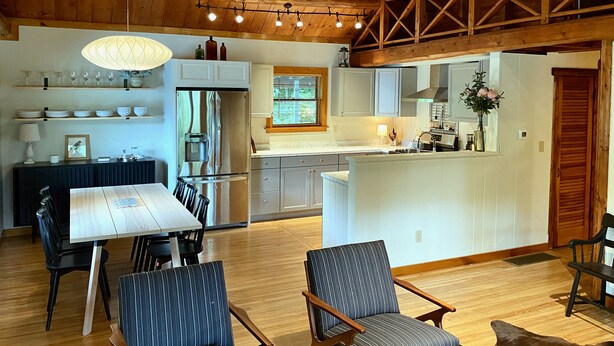 A spacious kitchen with a central island, wooden ceiling, and built-in cabinets.