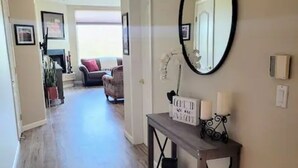 A hallway with wooden flooring, a console table with a mirror and candles, and a sign that reads "We are the best." - Beautiful Mountain Views and a spacious relaxing home in NW Tucson. (Tucson)