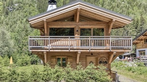 Eine Chalet mit Balkon, Holzhausexterieur und Bergblick.