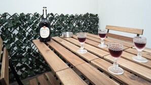 Ett träbord med en vinflaska och fyra glas rött vin.