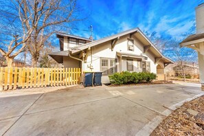 A two-story house with a covered porch and a fenced yard. - Brookside 3BR Home - Garage Parking + Pets! (Kansas City)