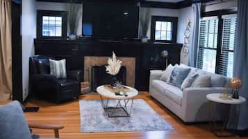 Cozy living room with a fireplace, two sofas, and a flat-screen TV.