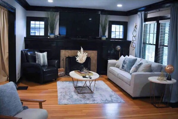 Cozy living room with a fireplace, two sofas, and a flat-screen TV.