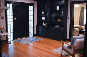 Experience a serene retreat with a sliding door, black shelving unit, and plush chair in a traditional Japanese-inspired space.