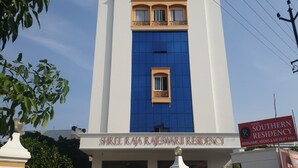 Un immeuble portant une enseigne indiquant « Shree Raja Rajeswari Residency » et une autre enseigne indiquant « Southern Residency », avec une liste des équipements disponibles.