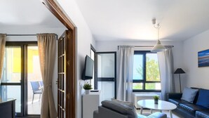 Ein modernes Wohnzimmer mit einer Couch, einem Couchtisch und einem an der Wand montierten Fernseher.