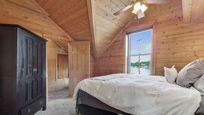 Una camera da letto con un letto, un'armadio in legno scuro e una finestra vista verde.