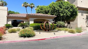 A building with a tiled roof, a central sculpture, and a landscaped garden with various plants. - Excellent location,Relax in the heart of the City (Phoenix)