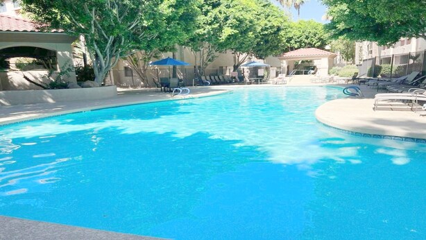 A clear blue pool with lounge chairs and umbrellas, surrounded by trees and buildings. - Excellent location,Relax in the heart of the City (Phoenix)