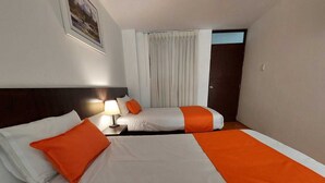 A hotel room with two beds, a nightstand with a lamp, a door, and a window with curtains. - Hotel Toulouse Arequipa (Arequipa)