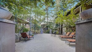 Un patio al aire libre con sillones de descanso y un camino empedrado.