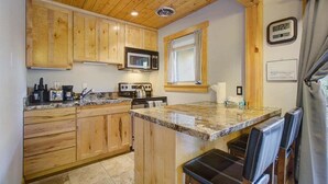Una cocina con armarios de madera, microondas, estufa y lavaplatos.
