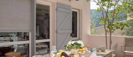Une table à manger dressée pour le petit-déjeuner, avec vue sur les montagnes.