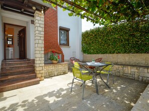 Un patio con chimenea de ladrillo, sillas amarillas y una mesa.