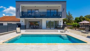A modern two-story house with a swimming pool, outdoor seating, and a covered patio area. - Villa Palma by Interhome (Krk/Pinezići)