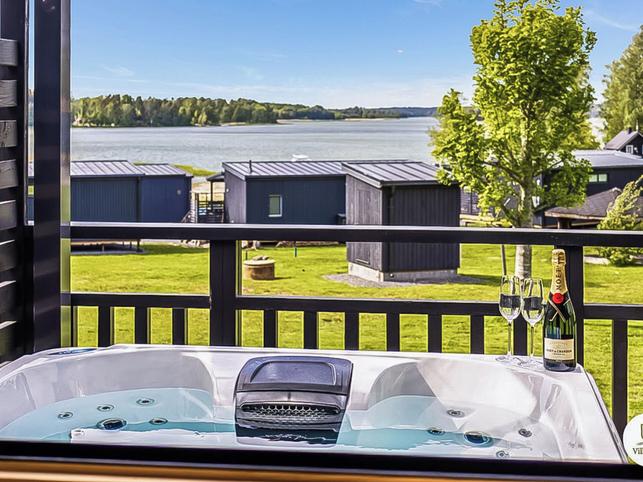 Uma banheira de hidromassagem com vista para um lago e edifícios.