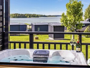 Uma banheira de hidromassagem com vista para um lago e edifícios.