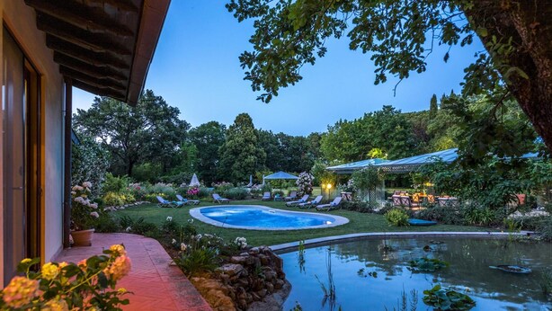 A well-maintained garden with a swimming pool, lounge chairs, and a small pond. - Villa Mimmina 8 in Civitella in Val di Chiana (Civitella in Val di Chiana)