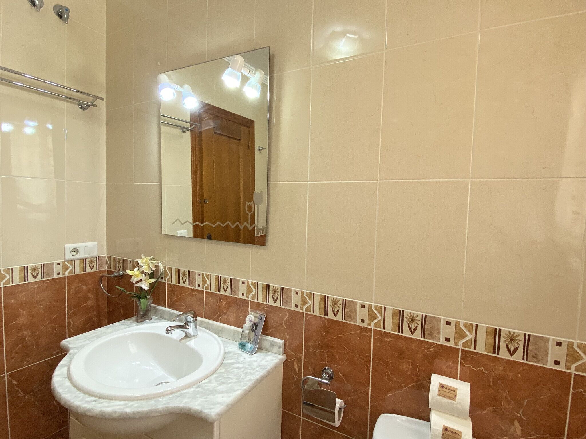 A bathroom with a sink, mirror, and towel rack.