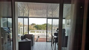 Un interior moderno con una puerta de cristal que da a un patio exterior.