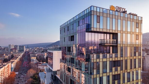 A modern building with a glass facade and a visible sign that reads "ONYX". -  Onyx City Center (Tbilisi)