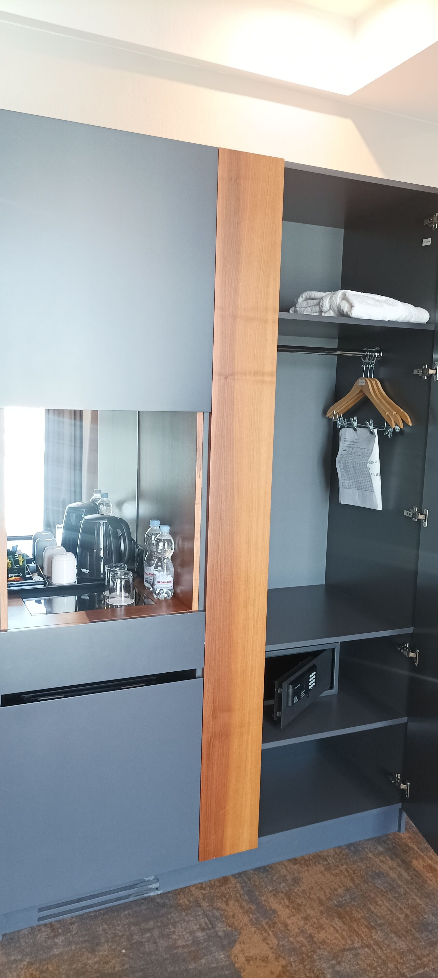 Quarto moderno com roupeiro embutido, um espelho e um espaço para café.