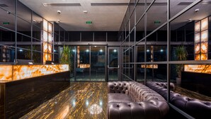 A modern lobby with a reception desk, leather seating, and glass walls. -  Onyx City Center (Tbilisi)