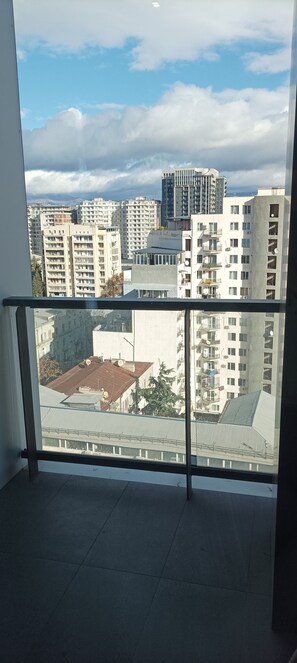 A balcony with a view of a cityscape, featuring multiple high-rise buildings and a clear sky. -  Onyx City Center (Tbilisi)