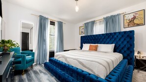 A bedroom with a large bed, a desk, and a chair. - Casa Del Exotique | Walk Everywhere | AC | Beach (Traverse City)