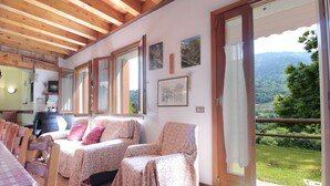 Una habitación con dos camas, una mesa de comedor y vistas a un paisaje verde.