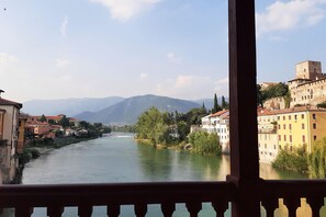 A riverside view with buildings and mountains in the background. - Belvilla by OYO Casa Lilla (Lastebasse)
