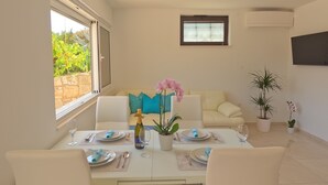A dining area with a table set for two, a bottle of champagne, and a potted orchid.