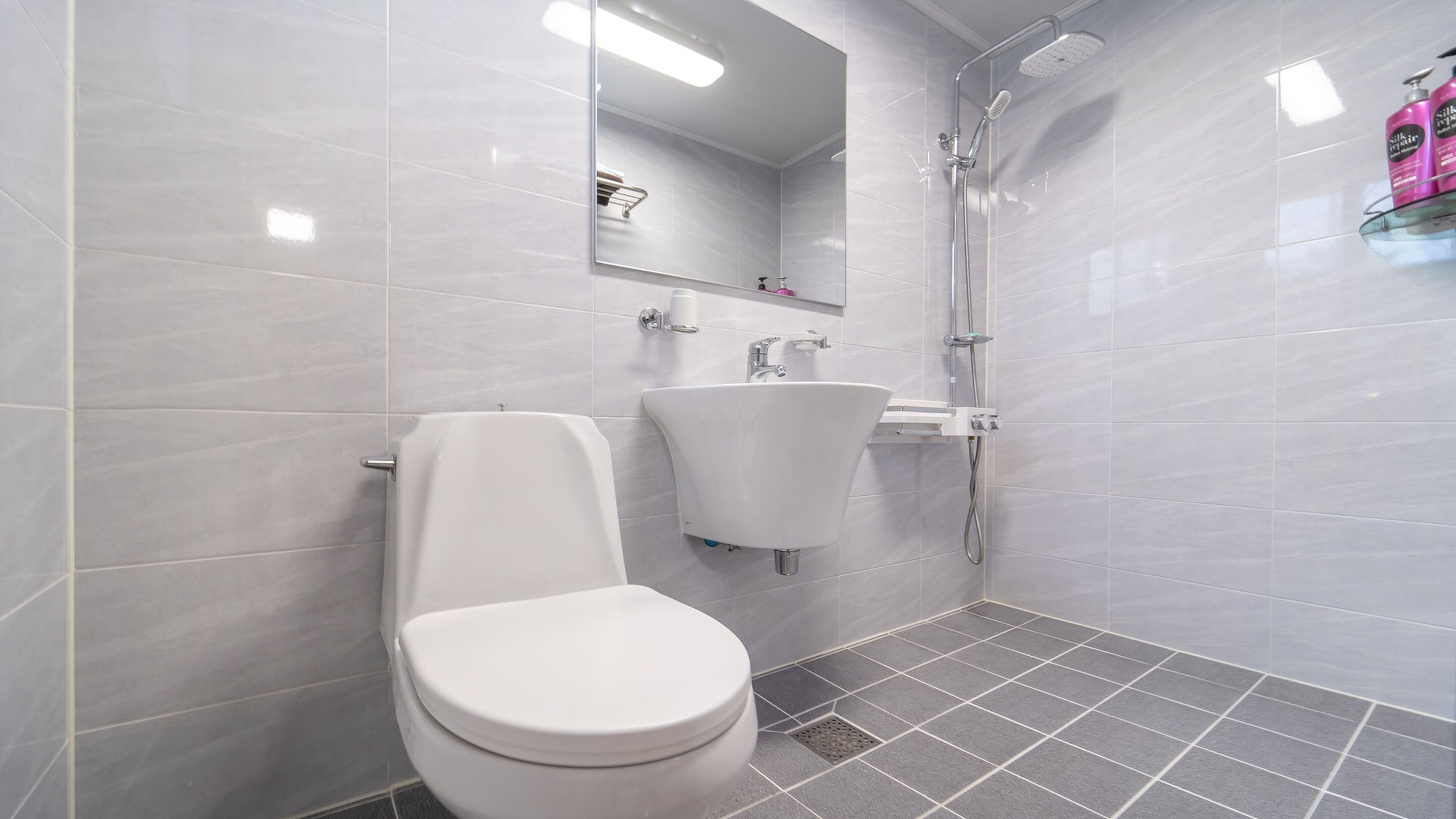 Ein modernes Badezimmer mit Toilette, Waschbecken und Dusche.