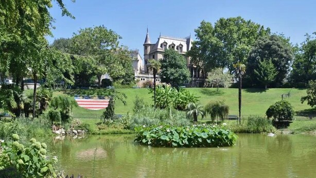 A park with a pond, lush greenery, and a building with a tower in the background. - INDUSTRIAL#CENTER#STATION#WIFI@SLEEPNTRIPBEZIERS (Béziers)