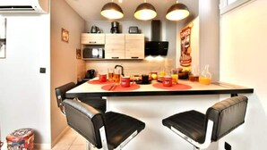 A modern kitchen with a central island, black bar stools, and a dining area. - INDUSTRIAL#CENTER#STATION#WIFI@SLEEPNTRIPBEZIERS (Béziers)