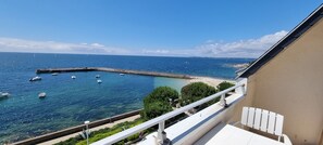 A balcony with a view of the sea, a pier, and a beach. - Superb sea view for this apartment in the center of Concarneau with parking. (Concarneau)