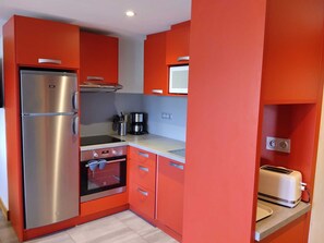 A compact kitchen with a stainless steel refrigerator, a stove, and a toaster. - Renovated apartment 8 ppl · Pool · Sauna · Hammam · Pets OK (La Plagne Montchavin Les Coches)