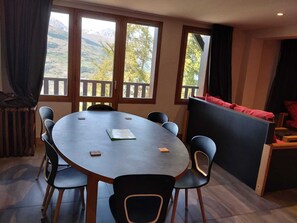 A round table with six chairs, a small book, and a remote control on it. - Renovated apartment 8 ppl · Pool · Sauna · Hammam · Pets OK (La Plagne Montchavin Les Coches)