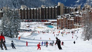 A ski resort with multiple buildings, a ski slope, and a pool area.