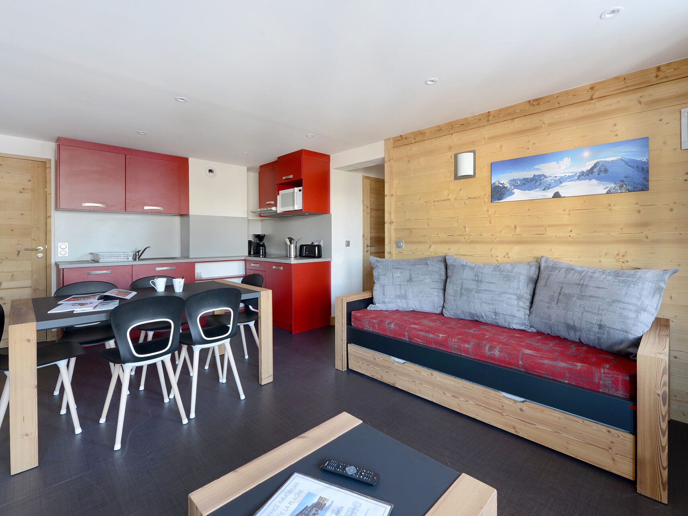 A compact living space with a kitchenette, dining area, and a sofa.