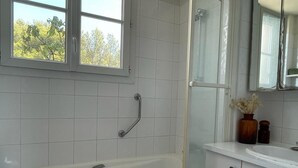 A modern bathroom with a bathtub, a shower, and a vanity with a mirror. - Sea view apartment with terrace, 3bedroom, 200m from Mourillon beaches (Toulon)